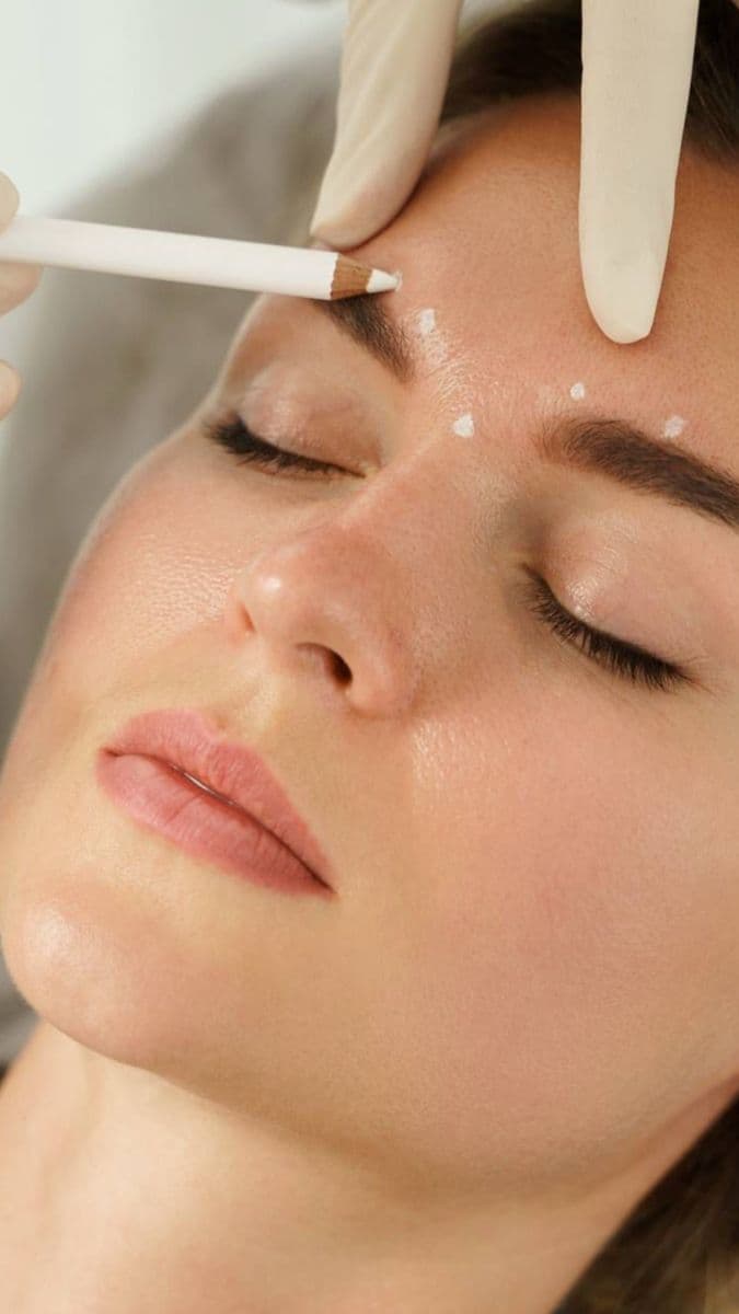 Close-up of a nurse administering a lines and wrinkles injection near a client's temple